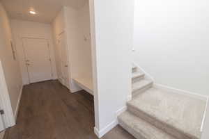 Staircase featuring baseboards and wood finished floors