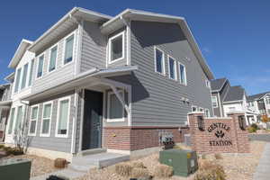 View of side of property featuring brick siding and a residential view