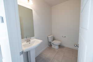 Half bath featuring light tile patterned floors and toilet