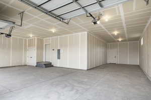 Garage featuring electric panel and a garage door opener