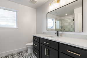 Bathroom with vanity, light tile patterned floors, and a shower