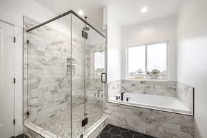 Bathroom featuring a garden tub, a shower stall, dark tile patterned floors, and recessed lighting