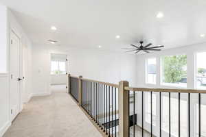 Corridor with recessed lighting and light colored carpet