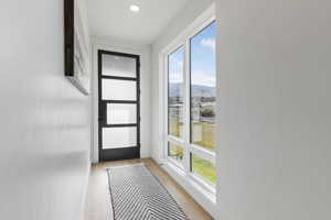 Doorway featuring wood finished floors, a water and mountain view, and recessed lighting