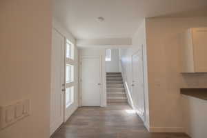 Hall with stairs and dark wood-style floors