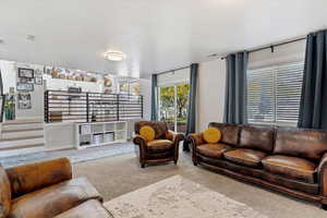 Living area featuring carpet and stairs