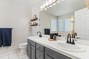 Full bathroom featuring light tile patterned flooring and double vanity