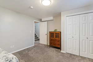 Bedroom featuring carpet, a textured ceiling, and a closet