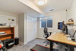 Office space with light carpet and baseboards