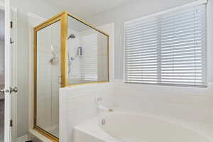 Full bathroom featuring a bath and a stall shower