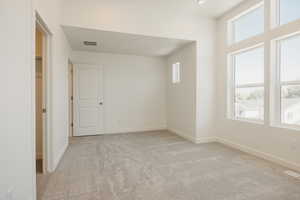 Empty room featuring light carpet and baseboards