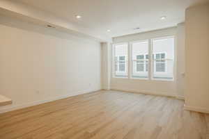 Empty room with light wood-style floors and recessed lighting