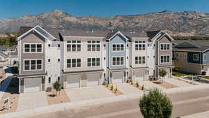 View of front of home with driveway, a residential view, and a mountain view
