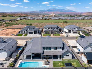 Aerial perspective of suburban area with a mountain backdrop and a pool