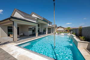 View of pool with a patio area, a fenced backyard, outdoor lounge area, and a pool with connected hot tub