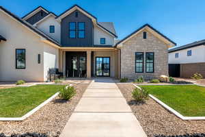 Property entrance with french doors, stucco siding, stone siding, a porch, and board and batten siding