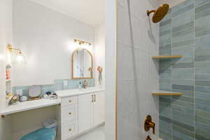 Full bath with vanity, tile walls, and a shower