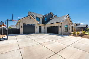 View of front of house featuring concrete driveway, a garage, and stone siding