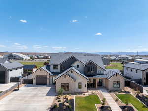 View of front of house with a residential view, driveway, stone siding, and a metal roof