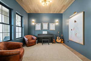 Sitting room featuring wood finished floors, wooden ceiling, and a chandelier