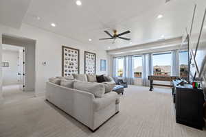 Living area with light carpet, recessed lighting, and a ceiling fan
