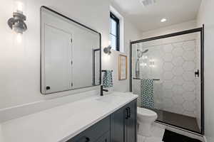 Full bathroom with vanity, a stall shower, light tile patterned floors, and recessed lighting