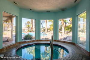 Community pool with a hot tub and a sunroom