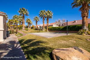 View of sport court featuring community basketball court, a yard, and a residential view