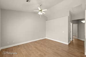 Unfurnished room with light wood-style floors, lofted ceiling, and a ceiling fan