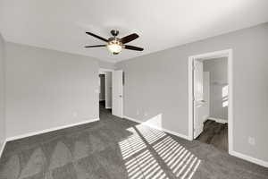 Unfurnished bedroom featuring dark colored carpet and ceiling fan