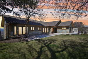 Back of house featuring a lawn, roof with shingles, and french doors