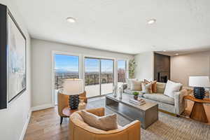 Living room featuring wood-type flooring, a brick fireplace, and recessed lighting