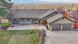 View of front of house featuring french doors, a shingled roof, stucco siding, and driveway