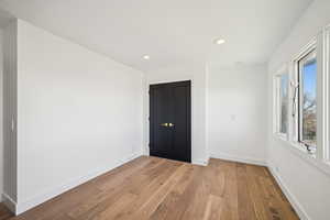 Unfurnished bedroom featuring light wood finished floors, recessed lighting, and a closet