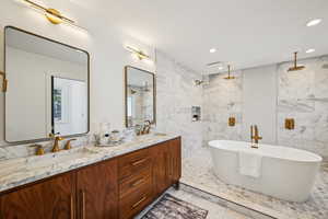 Bathroom featuring tile walls, a soaking tub, double vanity, recessed lighting, and a marble finish shower