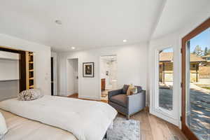 Bedroom with wood finished floors, access to exterior, and recessed lighting