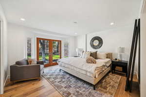 Bedroom with access to outside, french doors, light wood-type flooring, and recessed lighting