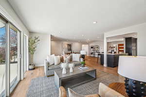 Living area with light wood finished floors and recessed lighting