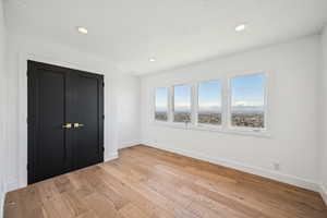 Unfurnished bedroom with a closet, light wood-style floors, and recessed lighting