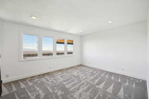 Carpeted empty room featuring baseboards and recessed lighting