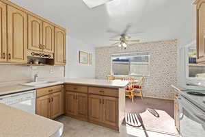 Kitchen with a peninsula, light countertops, open shelves, white appliances, and wallpapered walls
