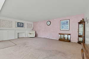 Unfurnished living room featuring carpet flooring and wallpapered walls