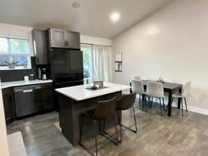 Kitchen featuring a kitchen island, dark wood finished floors, a kitchen breakfast bar