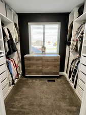 Walk in closet featuring dark colored carpet