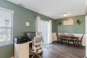 Home office with wood finished floors and a wainscoted wall