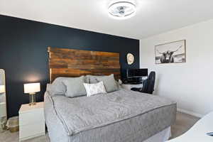 Bedroom featuring carpet floors and baseboards
