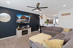 Living area with light colored carpet, ceiling fan, and recessed lighting