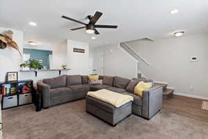 Living room with stairs, a textured ceiling, recessed lighting, and ceiling fan