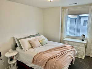 Bedroom featuring dark colored carpet