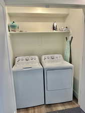 Washroom featuring light wood-style flooring and washing machine and dryer